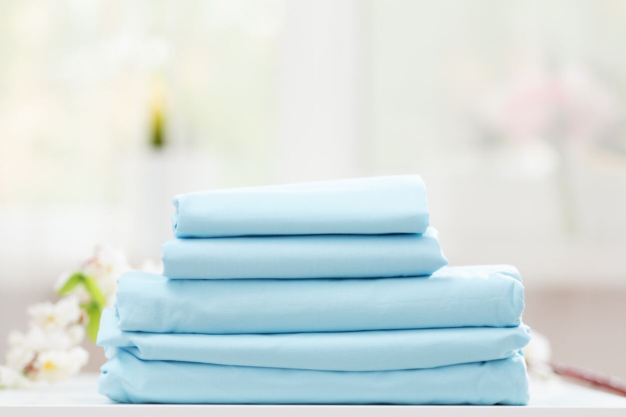 Stack of blue bed sheets on a table