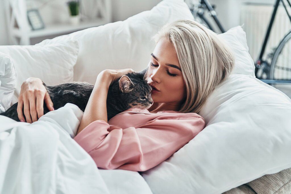 Cat being cuddlesd by a young woman