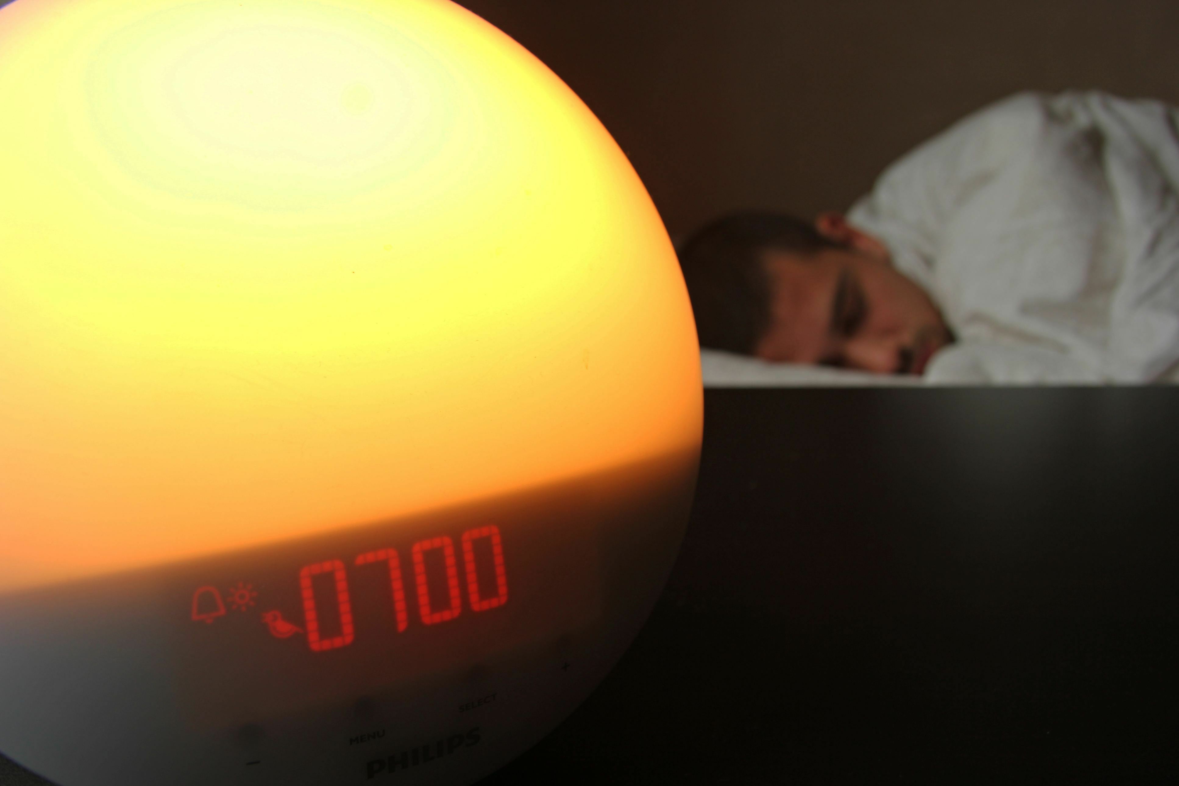 Man alsleep in bed with Alarm clock in foreground