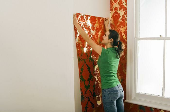 Woman hanging wallpaper