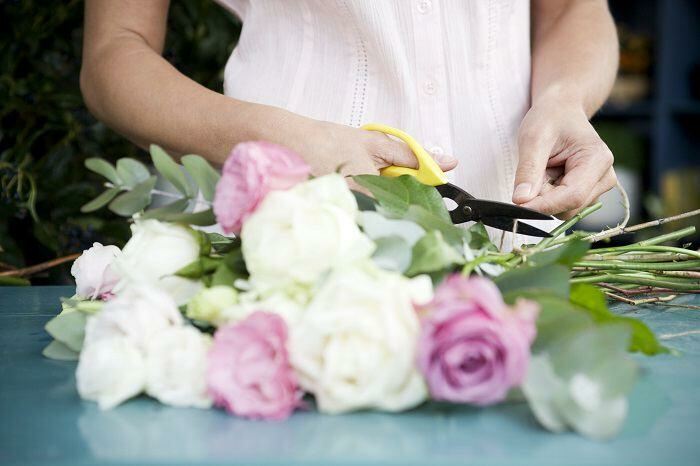 Woman arranging and trimming flowers